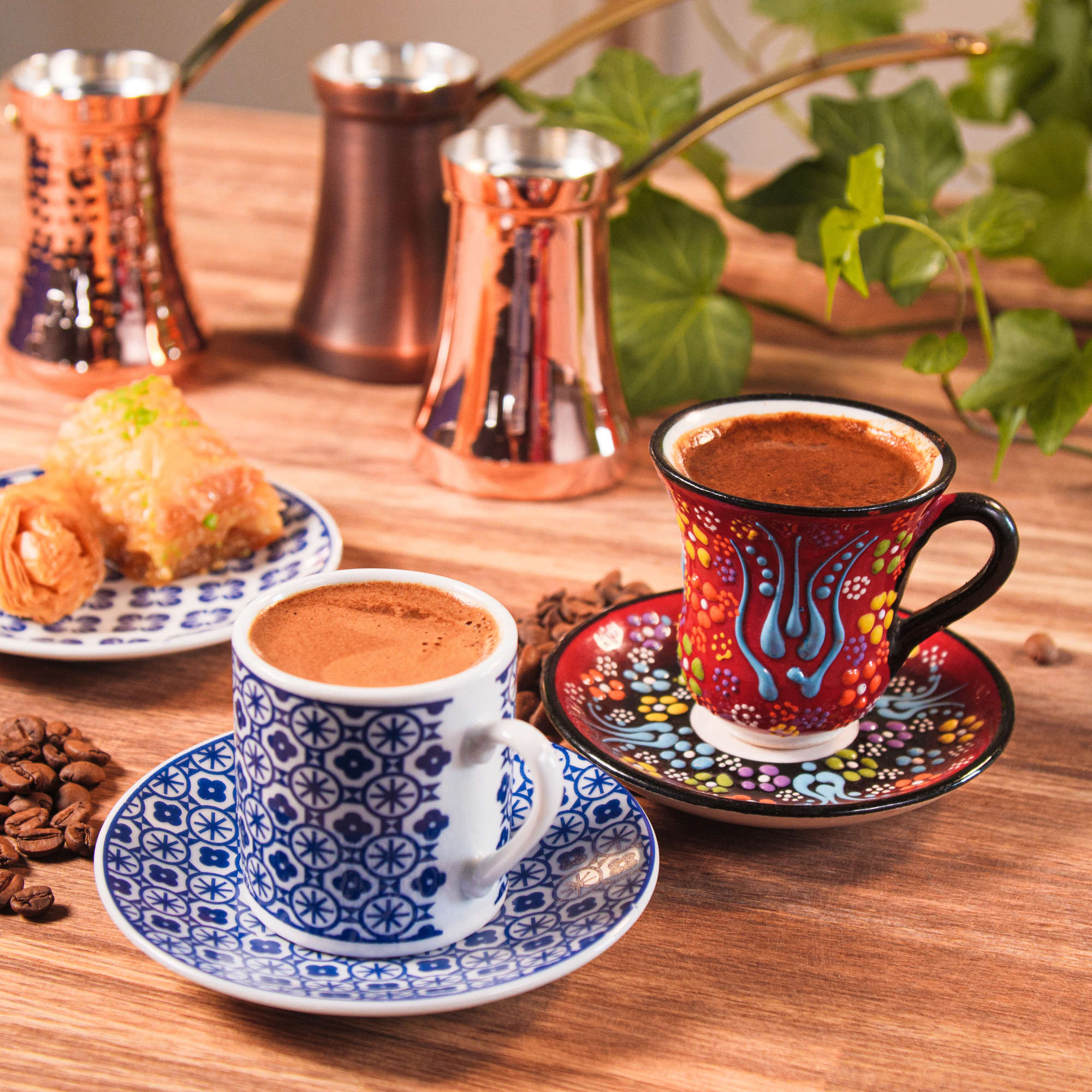 Turkish coffee in two cups with the sweets and cezve on the background